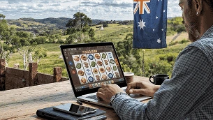 Person using a laptop with online casino games displayed, Australian flag in the background